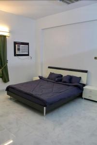 a bedroom with a large bed with purple pillows at شقه النزهه مكونه من غرفتين وصاله ودورتين مياه وغرفه طعام in Al Madinah