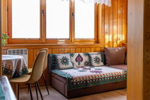 kanapę w pokoju ze stołem i oknami w obiekcie Apartamenty Parzenica w Zakopanem