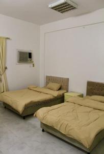 a bedroom with two beds and a window at شقه النزهه مكونه من غرفتين وصاله ودورتين مياه وغرفه طعام in Al Madinah