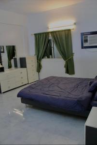 a bedroom with a bed and a dresser and window at شقه النزهه مكونه من غرفتين وصاله ودورتين مياه وغرفه طعام in Al Madinah