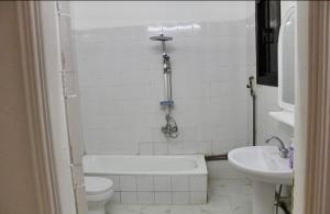 a bathroom with a tub and a toilet and a sink at شقه النزهه مكونه من غرفتين وصاله ودورتين مياه وغرفه طعام in Al Madinah