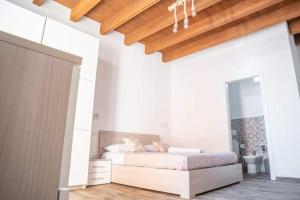 a white bedroom with a bed and a wooden ceiling at Il Germoglio in Bisceglie