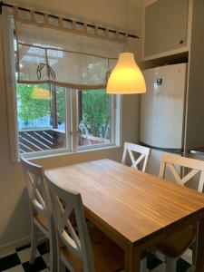 延雪平的住宿－Lägenhet på Strömsholm，厨房配有木桌和窗户。