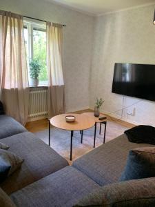 a living room with a couch and a table at Lägenhet på Strömsholm in Jönköping