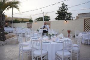 a man standing at a table with white tables and chairs at Il Germoglio in Bisceglie