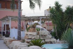 a fountain in front of a building with a palm tree at Il Germoglio in Bisceglie