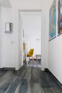 a hallway with a yellow chair in a white room at Affittacamere Angelica in Bacoli