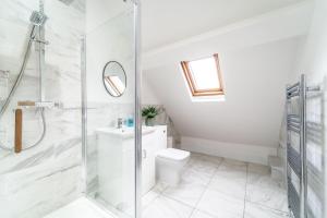 a white bathroom with a shower and a toilet at 8 The Quadrant Luxury Apartments - Hoylake in Hoylake