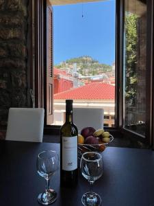 a bottle of wine sitting on a table with two glasses at Madame Parisienne in Nafpaktos