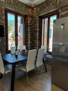 a kitchen with a table with chairs and a refrigerator at Madame Parisienne in Nafpaktos