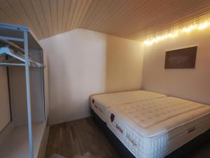 uma pequena cama num pequeno quarto com uma prateleira em Cosy appartement 1 chambre au coeur du bourg em Fribourg