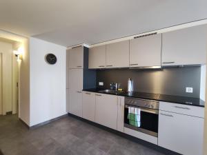 a kitchen with white cabinets and a stove at Cosy appartement 1 chambre au coeur du bourg in Fribourg