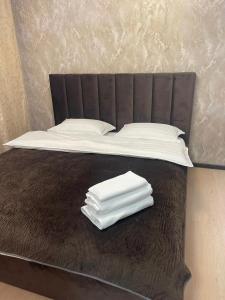 a bed with white towels sitting on top of it at Hotel LION Almaty in Almaty