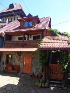 a house with a red door and a bench at Cottage Lisovychok in Vorokhta