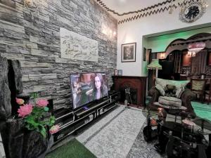 a living room with a tv and a stone wall at Albert Suites & Apartments Entebbe in Entebbe