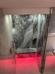 a bathroom with a shower with a rock wall at Domus De Cinti in Tivoli
