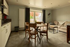 een keuken en een woonkamer met een tafel en stoelen bij Het Landsleven in Gingelom