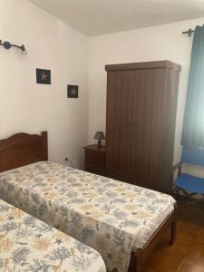 1 dormitorio con 2 camas y armario de madera en Casa Smeralda, en Olbia