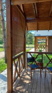 a screened porch with two chairs and a table at Domki Pod Lasem in Ostrowo