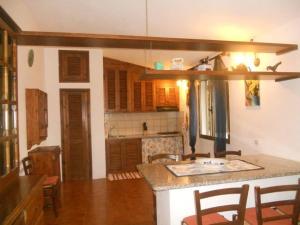 a kitchen with a counter and chairs in a room at Casa Smeralda in Olbia