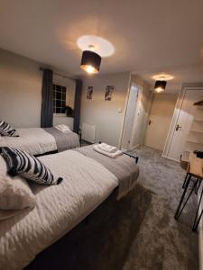 1 dormitorio con 2 camas, mesa y sillas en Ty Golchi - Cosy traditional cottage in Corris en Corris