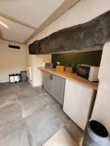 a kitchen with a counter and a microwave at Ty Golchi - Cosy traditional cottage in Corris in Corris