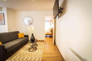 a living room with a couch and a table at L'Albatros 008 - Hypercentre Cosy Wifi in Saint-Quentin
