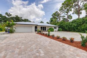 a house with a driveway and a garage at Vero Beach Vacation Rental Pool and Putting Green! in Vero Beach
