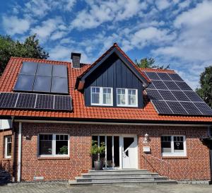 una casa con paneles solares en el techo en Ferienwohnung am Dörenberg en Georgsmarienhütte