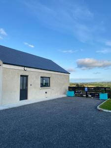 a large white building with a black roof at Hill Top View Apartment Lahinch in Lahinch