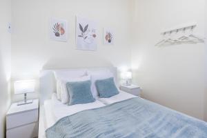 1 dormitorio blanco con 1 cama y 2 lámparas en Hyper Central - NEW - Very Small Studio, en Budapest