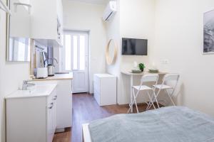 cocina blanca con cama y escritorio en Hyper Central - NEW - Very Small Studio, en Budapest 10 fotos más