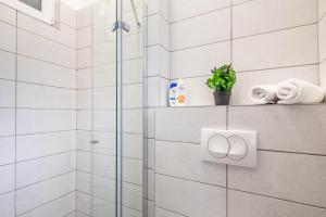 Un baño con ducha con azulejos blancos. en Hyper Central - NEW - Very Small Studio, en Budapest