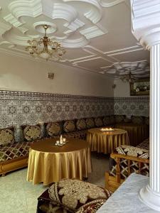 una stanza con due tavoli e sedie e un soffitto di Sfiha/Hoceima huis ad Al-Ḥoseyma