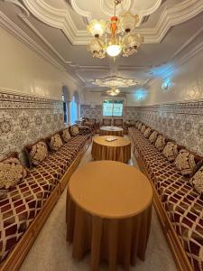 una habitación con hileras de mesas y sillas en Sfiha/Hoceima huis, en Alhucemas