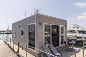 Marina del Gargano Houseboat في مانفريدونيا: منزل صغير على رصيف بجوار قارب