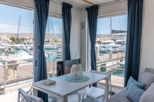 a living room with a table and a view of a marina at Marina del Gargano Houseboat in Manfredonia