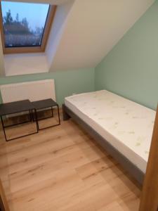 mały pokój z łóżkiem i ławką w obiekcie Dom Wypoczynkowy Nad Wisłą w mieście Puławy