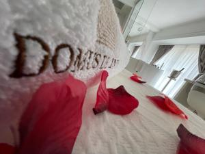 a bed with red rose petals on it at Domus De Cinti in Tivoli