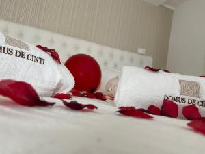 a bed with red roses and pillows on it at Domus De Cinti in Tivoli
