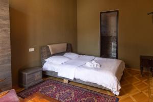 um quarto com uma cama com um gato deitado sobre ela em Wine House em Tbilisi