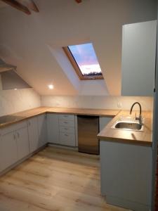 eine Küche im Dachgeschoss mit einem Waschbecken und einem Fenster in der Unterkunft Dom Wypoczynkowy Nad Wisłą in Puławy
