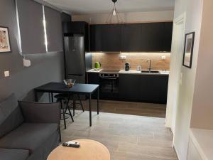a kitchen with a couch and a table in a room at Chic fully equipped Studio Apart - Netflix - Wi-Fi in Piraeus