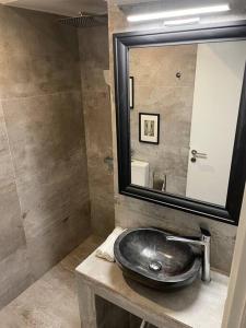 a bathroom with a sink and a mirror at Chic fully equipped Studio Apart - Netflix - Wi-Fi in Piraeus