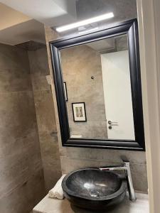 a bathroom with a black sink and a mirror at Chic fully equipped Studio Apart - Netflix - Wi-Fi in Piraeus