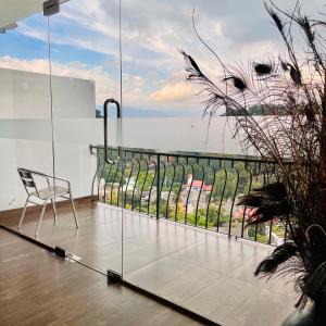 a chair on a balcony with a view of the ocean at Blinkbonnie Inn in Kandy