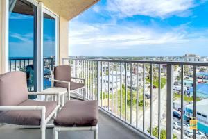 a balcony with two chairs and a view of a city at Oceania Beach Club Superior Beachfront Condos in New Smyrna Beach