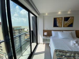 Un dormitorio con una cama y una ventana grande. en Bela Hospedagem - #Neo Duos 802 Charme em Intermares, en Cabedelo 21 fotos más
