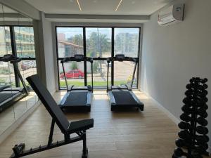 un gimnasio con 3 cintas de correr y una gran ventana en Bela Hospedagem - #Neo Duos 802 Charme em Intermares, en Cabedelo