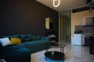 a living room with a blue couch and a table at Diamond Apartments Niš in Niš +110 photos